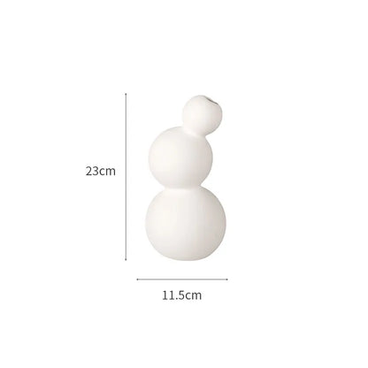 مجموعة من المزهريات الخزفية البيضاء لتزيين المنزل.